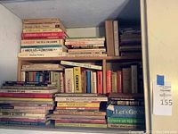 Wide shot showing a shelf of books focused on nutrition, health, and medicine with titles visible on the spines such as 'Cancer Facts & Fallacies,' 'Healing Factor,' and 'Medical Botany'.