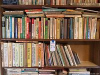 Top three shelves filled with health and nutrition books including titles like 'Healing with Vitamins', 'Miracle Healing Herbs', and 'Laetrile Cancer Treatment'. Bottom shelves have magazines and pamphlets.