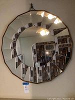 Front view of circular mirror showing multi-faceted frame creating a spiral reflection effect.