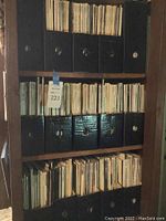 Shelf with three rows of black magazine holders filled with vintage magazines showing upright spines