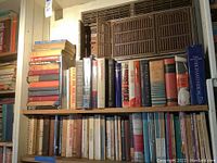 Bookshelves filled with multiple used books predominantly on history and politics. Close focus on book titles and spines to convey lot contents.