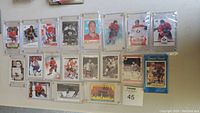 Overview of 19 hockey cards laid out on a flat surface, all housed within protective screwdown or snap lock holders. Varied card designs and eras visible.