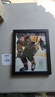Front view showing the framed signed photo of Paul Coffey in Pittsburgh Penguins jersey number 77 skating on ice.