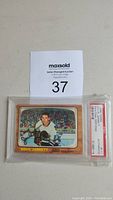 Front view of the 1966 Topps #111 Doug Jarrett hockey card with visible autograph and PSA/DNA authentication case.