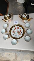 Full view of Chinese dragon and phoenix porcelain tea service including two teapots, seven cups, and 10-inch serving tray.