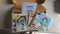 Box with assorted hockey cards showing front cards including Wayne Dillon and Ron Graham
