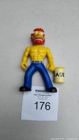 Front view of Ragin Willie action figure holding Barrel of Grease with auction lot number attached