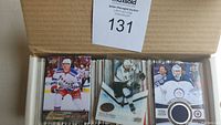 Open box showing front row of hockey cards including a Brad Richards Young Guns rookie card, an insert patch card from Upper Deck of a San Jose Sharks player, and a Winnipeg Jets player insert.