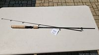 Full view of the 6-foot fishing rod with cork handle laid on a white table, showing the rod's design and length.