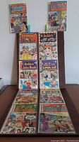 Two stacks of comic books including Josie and the Pussycats, Sabrina, Everything's Archie, Archie's Joke Book, Archie TV Laugh-Out, and other Archie comics displayed on a flat surface.