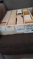 Wide shot of cardboard storage box showing multiple compartments of basketball cards with handwritten labels for various brands and years