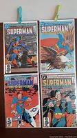 Four Superman comic book issues from 'The Secret Years' mini series displayed with plastic clips, showing front covers featuring Superman in different action scenes.