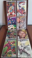 Full view of 8 DC Supergirl comic books arranged on a surface, showing cover art and variety of issues.