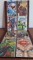 Photo showing front covers of 8 Superman comics including Superman #3 and Superman Adventures