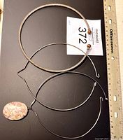 Full view of three metal choker necklaces with one pendant and rulers showing size.