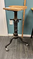 Full view of adjustable rolling workshop stand with wooden top on caster wheels