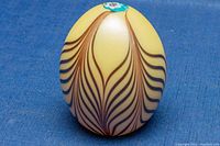 Yellow Murano glass paperweight with wavy brown lines around body