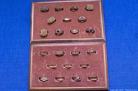 Overview of all 22 gold plated blank ring settings in display case with maroon lining