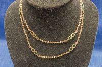 Full view of the 32-inch silver chain necklace with green teardrop-shaped crystal inserts around the chain.