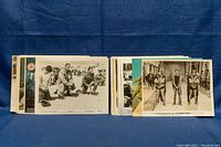 Two stacks of approximately 50 assorted 8x10 Hollywood film still and publicity photos, displayed on blue fabric background.