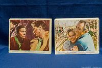 Stacks of 8x10 Hollywood film stills and publicity photos showing different cinematic scenes and actors.