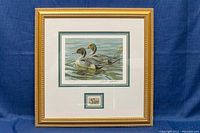 Framed limited edition print and small reproduction stamp under glass, gold frame with double mat