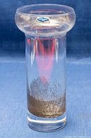 Front clear view of glass vase showing flared rim and bottom metal textured pattern.