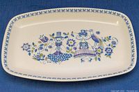 Top view of the rectangular ceramic serving dish showing the Lotte Turi folk art design in blue and green floral motifs with two stylized figures and a patterned border.