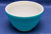 Side exterior view of the Primary Blue Pyrex mixing bowl showing smooth blue glass with white rim and interior.
