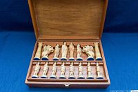 Open wooden case showing full set of cream and dark gray pieces in molded trays