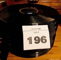 Stack of 80 black vinyl LP records with a lot number 196 label attached.