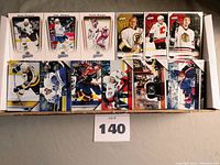 Top view of assorted hockey cards from 2004/05 Upper Deck MVP, 2005/06 Upper Deck Victory and others laid out in a box.