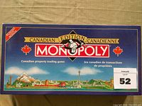 Blue Monopoly box featuring Canadian Edition branding and landmarks, with opened box visible.