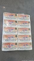 Full view of the sealed flat containing multiple $2 notes from 1988 World Expo Australia with colorful design and Expo banner.