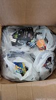 Top view of a large box containing several plastic bags filled with gift cards, mostly showing Walmart cards.