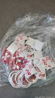 Loose plastic bag with various Budweiser and Michelob beer collectible buttons, some sealed in small white paper envelopes and others loose.