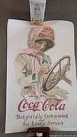 Full view of the vintage Coca Cola lithograph showing the woman holding Coca Cola bottle and text.