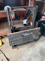 Black & Decker Workmate 225 portable project center and vise bench folded and stored in a garage.