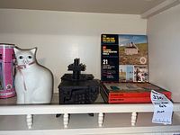 View of cat bank, two black cast iron miniature stoves, and stack of Talking View-Master reels with visible labels.