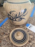 Full frontal view of jar with matching lid removed, shows hand painted decoration and embossed lettering