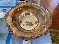 Top view showing the wide ornate rim with floral pattern and the interior bowl surface with patina.
