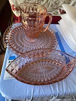 Photo of pink depression glass pitcher, platter and bowl with diamond geometric pattern