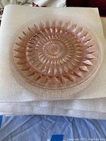 Top view of pink depression glass plate showing starburst pattern and clear pink translucent glass.