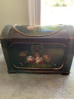 Front view of wooden chest showing floral hand-painted design and metal latch