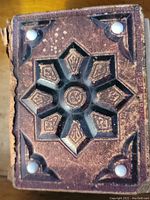 Photo of the ornate leather cover with embossed design and decorative white studs
