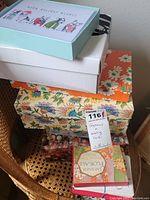 Stack of multiple decorative boxes containing stationery and greeting cards, including floral and patterned designs.