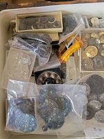 Overview photo showing multiple plastic bags and boxes with a variety of vintage buttons in different shapes and colors.