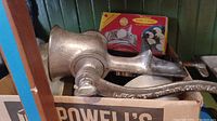 Vintage metal meat grinder with crank handle and part of box with other items