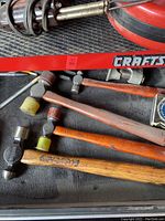 Multiple Craftsman hammers with wooden and composite handles on black surface, visible wear and use marks.