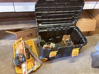 View looking down into storage case and additional yellow container with hand tools and hardware